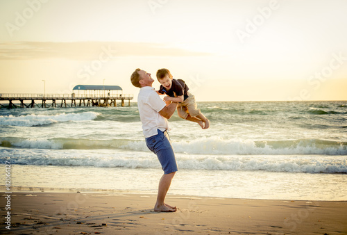 happy father throwing up little son in beach summer holidays