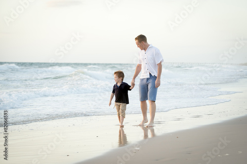 happy father and little son walking on beach parenthood concept
