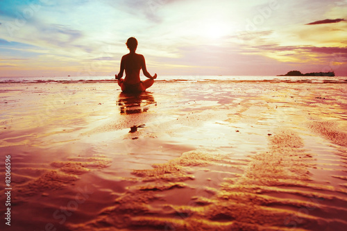 фотографія enlightenment, silhouette of woman practicing yoga on the beach