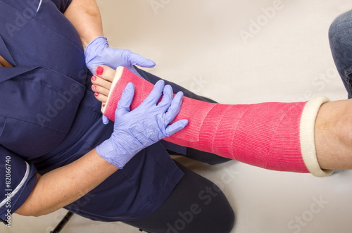 Fototapet Ladies leg in Cast being treated by a Nurse