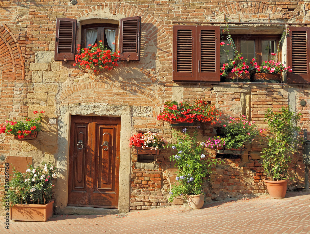 Fototapeta premium piękne drzwi do toskańskiego domu zdobione kwiatami