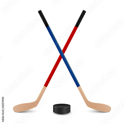 Two crossed hockey sticks and puck. photo