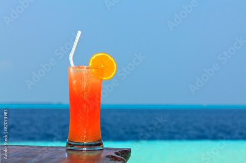 Glass of drink is on a beach table