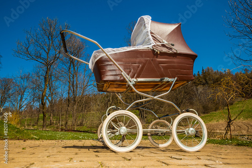 Retro style baby carriage outdoors on sunny day