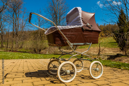 Retro style baby carriage outdoors on sunny day