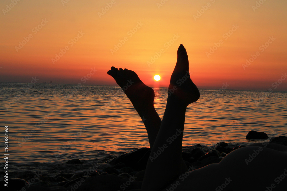 Naked woman legs and evening beach on the sunset Stock Photo Adobe Stock