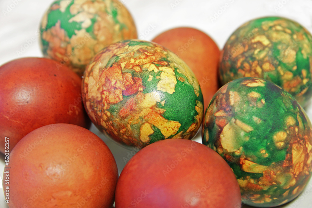 Colorful Easter eggs on white plate placed by heap Colorful Easter eggs on white plate placed by heap