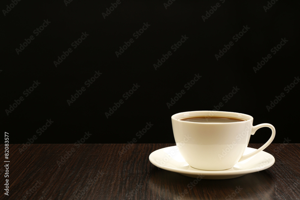 Cup of coffee on wooden table, on dark background Cup of coffee on wooden table, on dark background