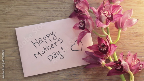 Mothers day card with flower on wooden board, top view
