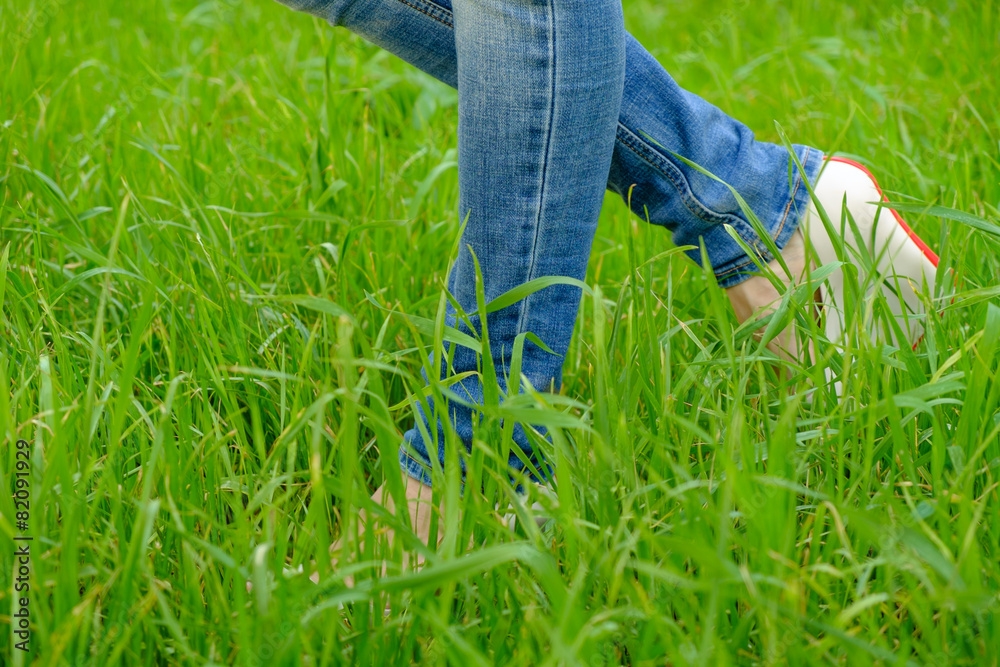 Female feet in shoes with wedge heels on green grass