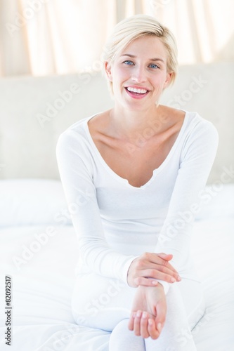 Pretty blonde woman smiling at the camera while sitting