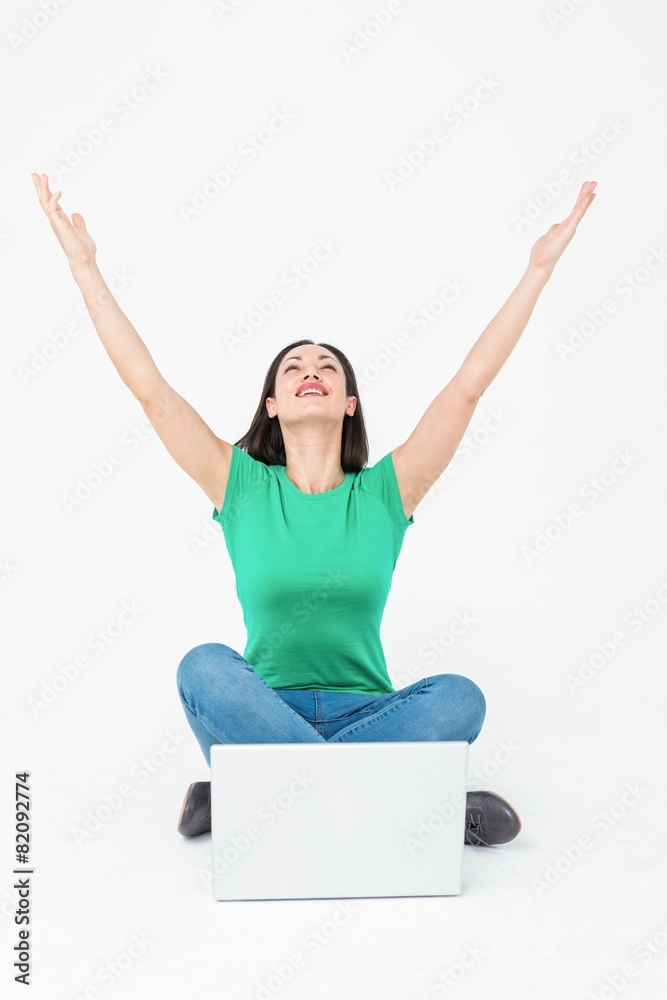 Happy brunette cheering in front of her laptop Happy brunette cheering in front of her laptop
