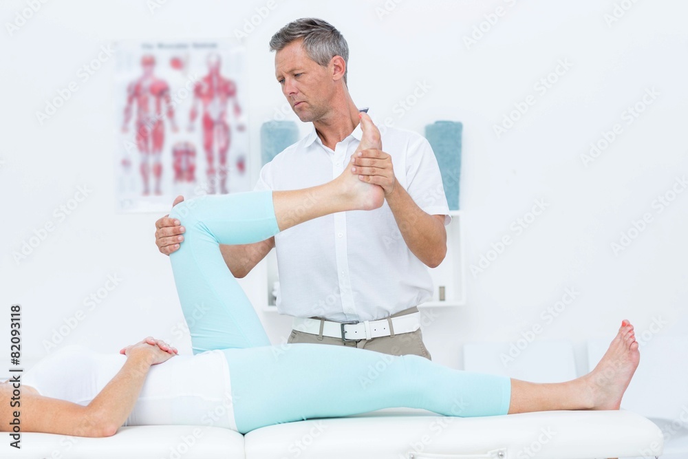 Obraz premium Doctor stretching his patients leg