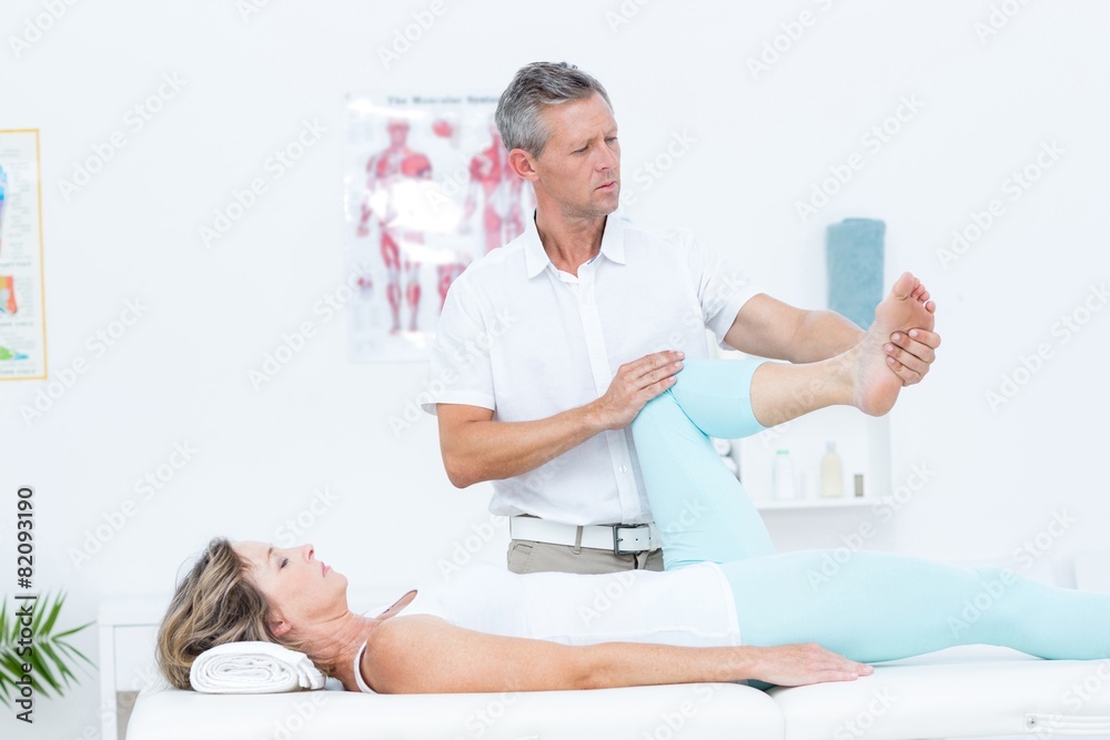 Fototapeta premium Doctor stretching his patients leg