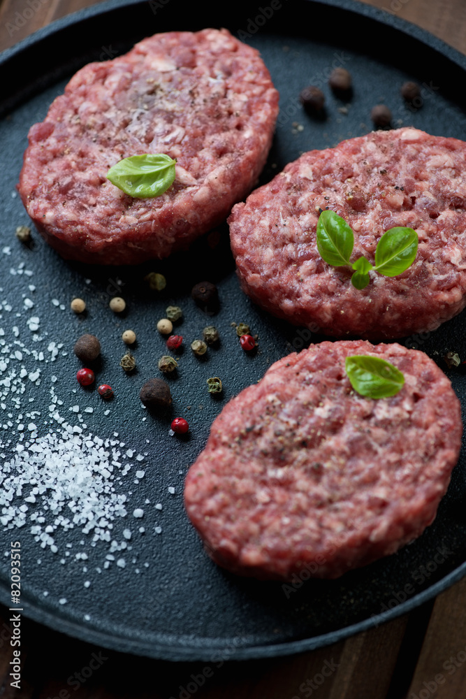 Raw beef cutlets with spices, close-up, studio shot Raw beef cutlets with spices, close-up, studio shot