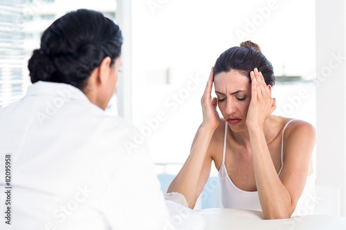 Woman grimacing in front of her doctor