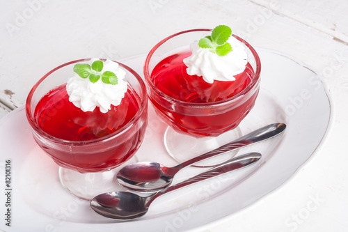 Red jelly with whipped cream in a glass bowl