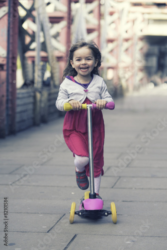 Little girl ridding scooter