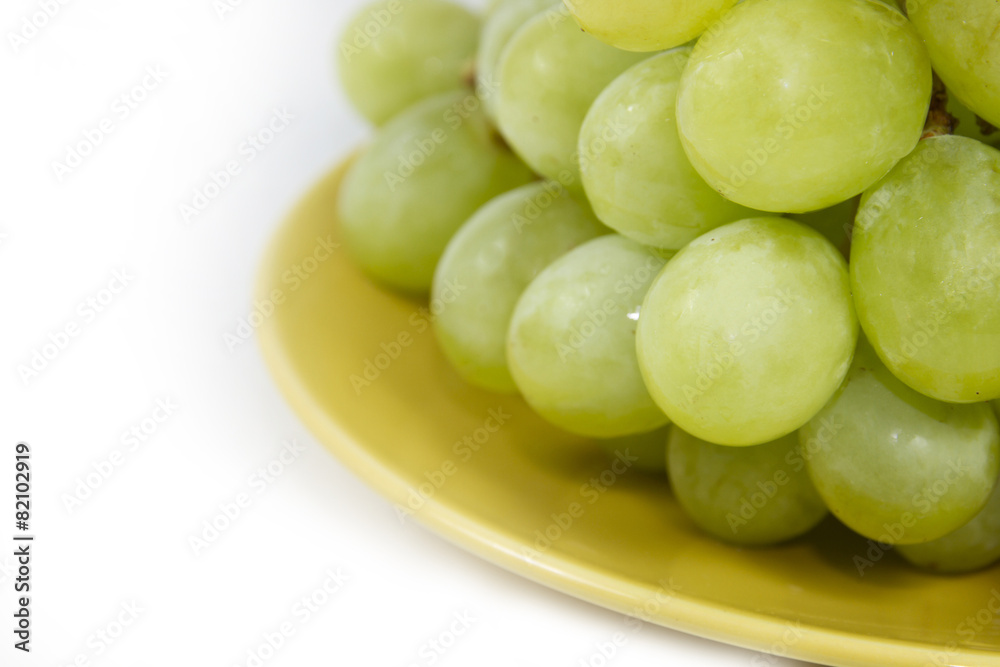 green grape on yellow plate on white screen green grape on yellow plate on white screen