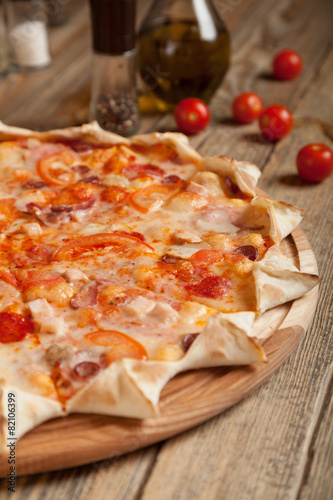 Italian pizza "Bavarian" on a wooden table.