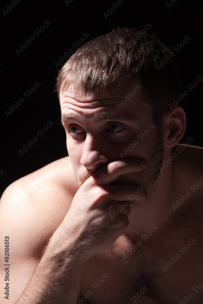 Image of shirtless man keeping his hand by face