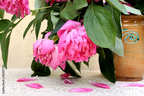 Wilted pink flowers in an old ceramic vase