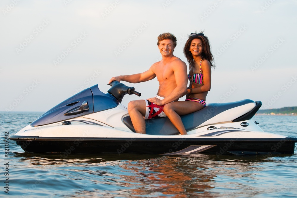 © Nejron Photo - Multinational couple sitting on a jet ski