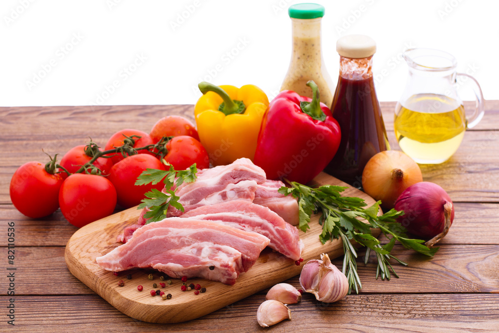 Food. Raw meat for barbecue with vegetables on wooden surface. Food. Raw meat for barbecue with vegetables on wooden surface.