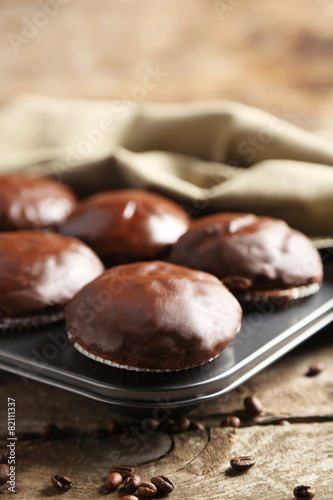 Tasty homemade chocolate muffins on wooden table