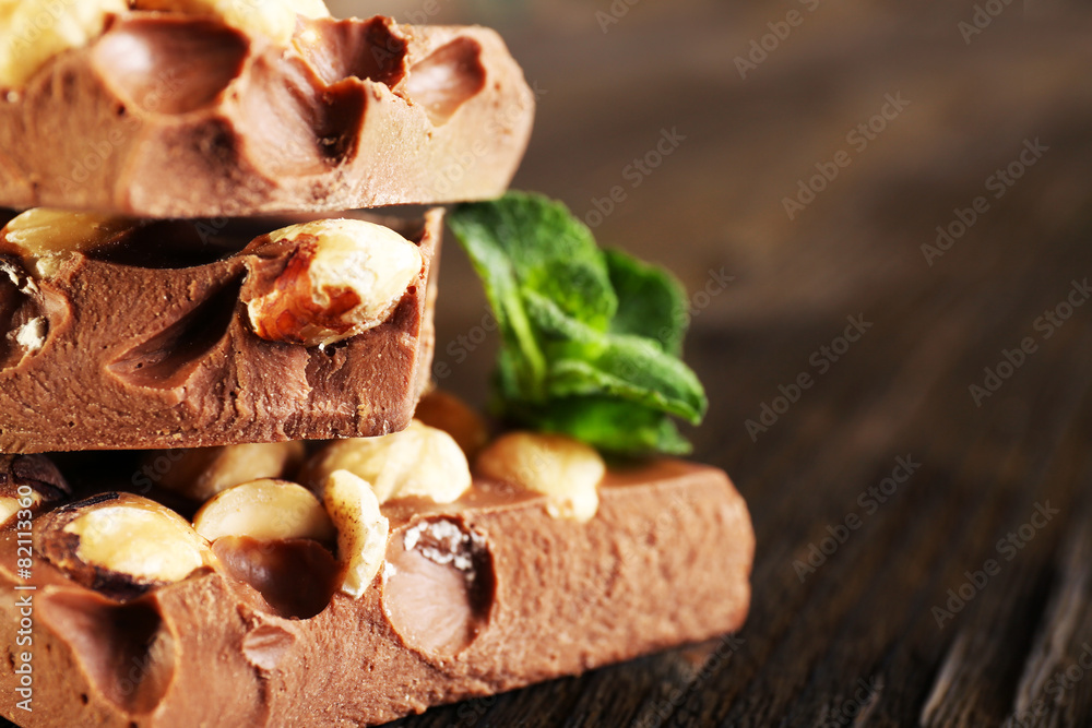 Stack of chocolate with nuts on wooden table, closeup Stack of chocolate with nuts on wooden table, closeup