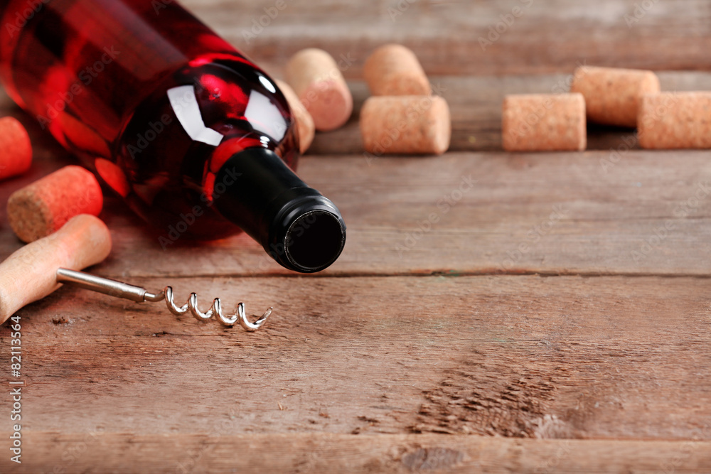 Glass bottle of wine with corks and corkscrew