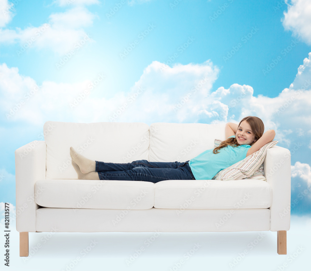smiling little girl lying on sofa