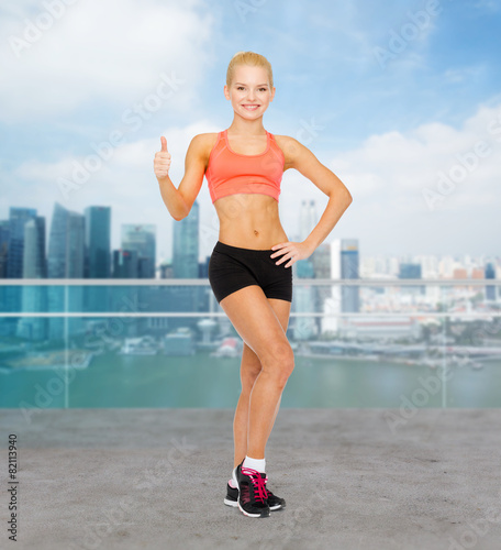 beautiful athletic woman showing thumbs up