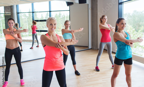 group of happy women working out in gym