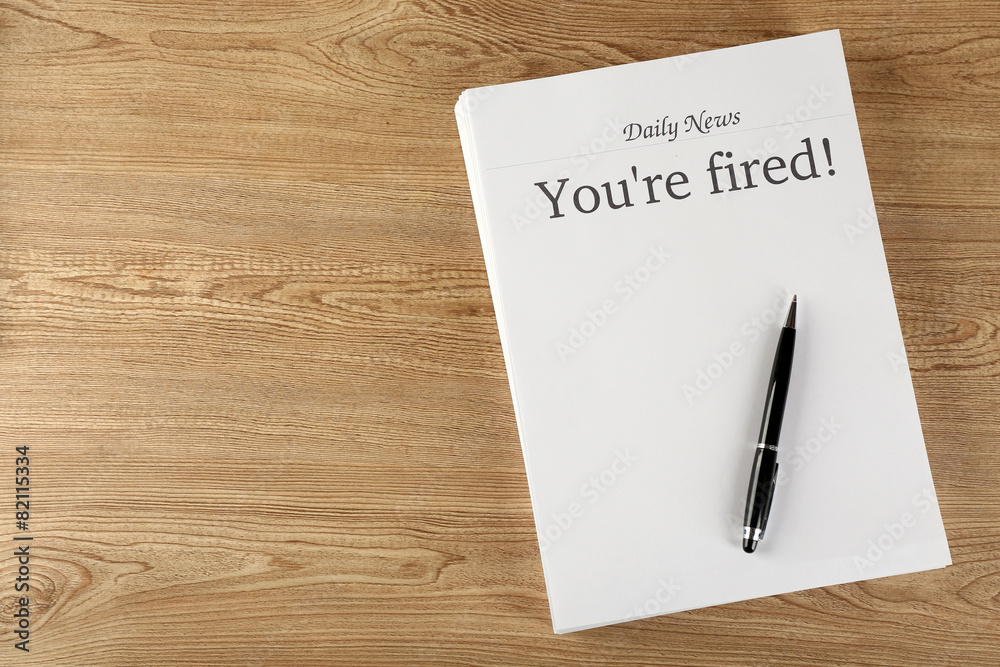 Message You're Fired on wooden table, top view Message You're Fired on wooden table, top view