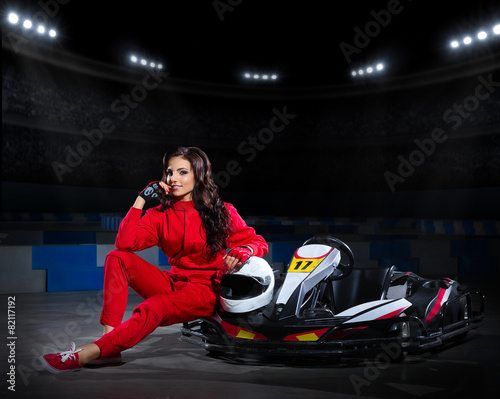 Girl racer with kart at stadium
