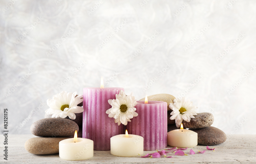 Still life with spa candles on light wallpaper background