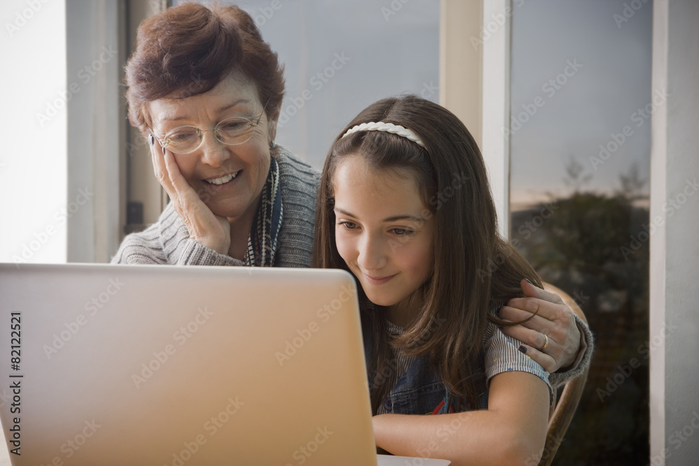 Older Hispanic woman using laptop with granddaughter Older Hispanic woman using laptop with granddaughter