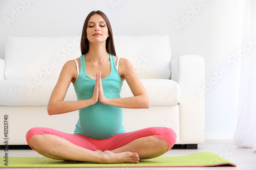 Pregnant woman exercising on green mat in room Free Download Pregnant woman exercising on green mat in room - GFXLoad
