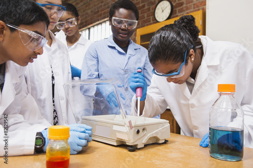 Teacher and students working in science lab photo