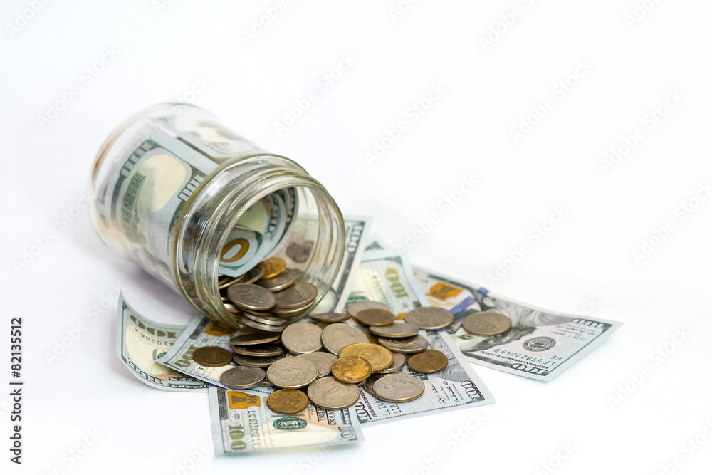 Horizontal shot of coins spilling from coin jar Horizontal shot of coins spilling from coin jar
