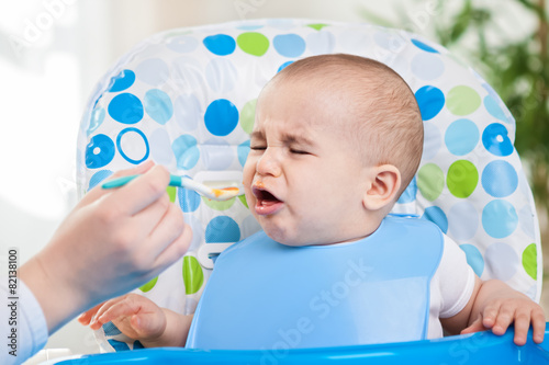 Angry baby doesn't like fruit mash