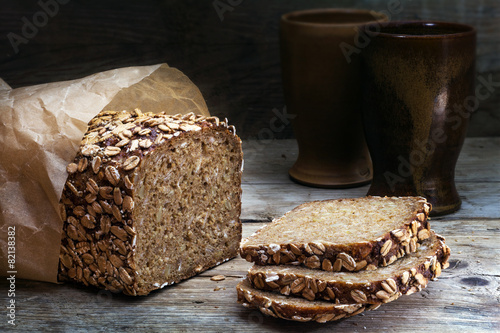 wholegrain bread with seeds on weathered wood, dark background photo