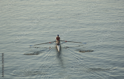 Person rowing sculling boat on river photo