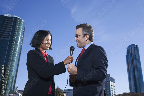 African female reporter interviewing businessman photo