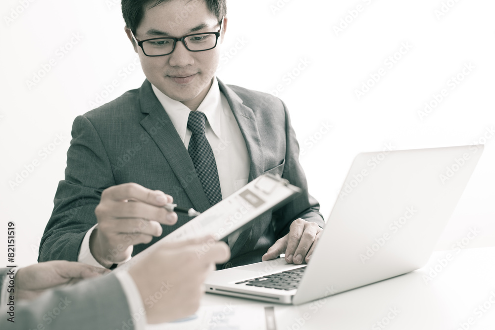 Two businessmen looking at report and having a discussion in off