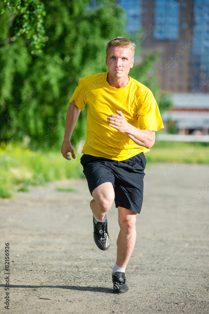 Sporty man jogging in city street park. Outdoor fitness. Sporty man jogging in city street park. Outdoor fitness.