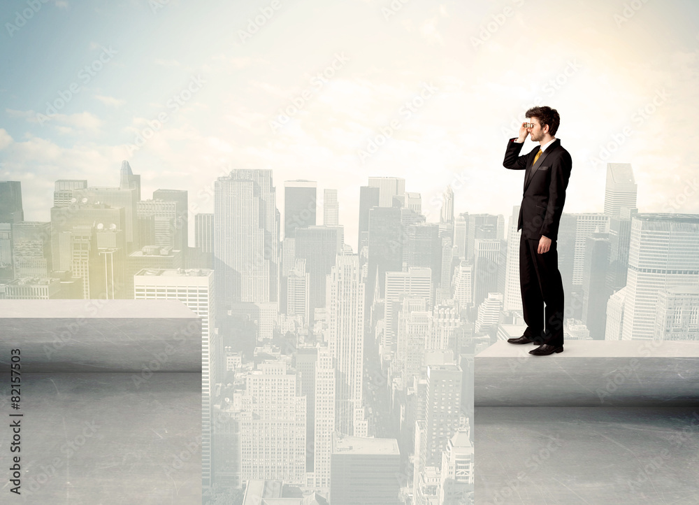 Businessman standing on the edge of rooftop Businessman standing on the edge of rooftop