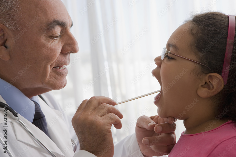 Hispanic doctor checking patient's throat Hispanic doctor checking patient's throat