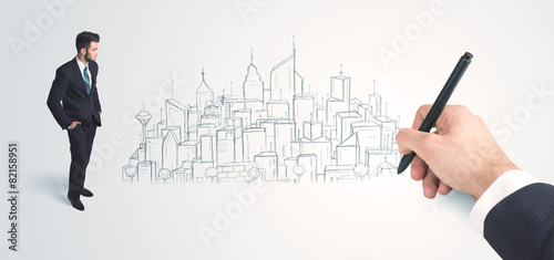 Businessman looking at hand drawn city on wall